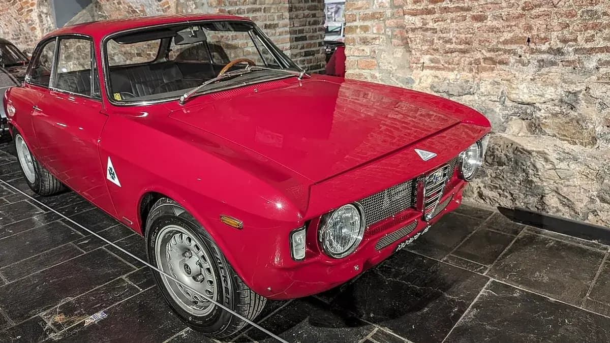 The red Alfa Romeo Giulia Sprint GTA displayed against a stone wall in the Spa-Francorchamps Circuit Museum