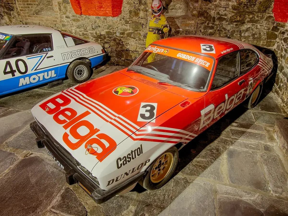 The Ford Capri 3.0 in Belga livery on display in the Spa-Francorchamps Circuit Museum, Gordon Spice's name on the windscreen banner, next to a TWR Mazda RX-7
