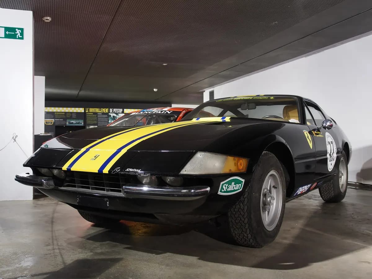 A car presented as a Ferrari 365 GTB/4 Daytona, black with yellow and blue stripes and number 27, on display in the Spa-Francorchamps Circuit Museum