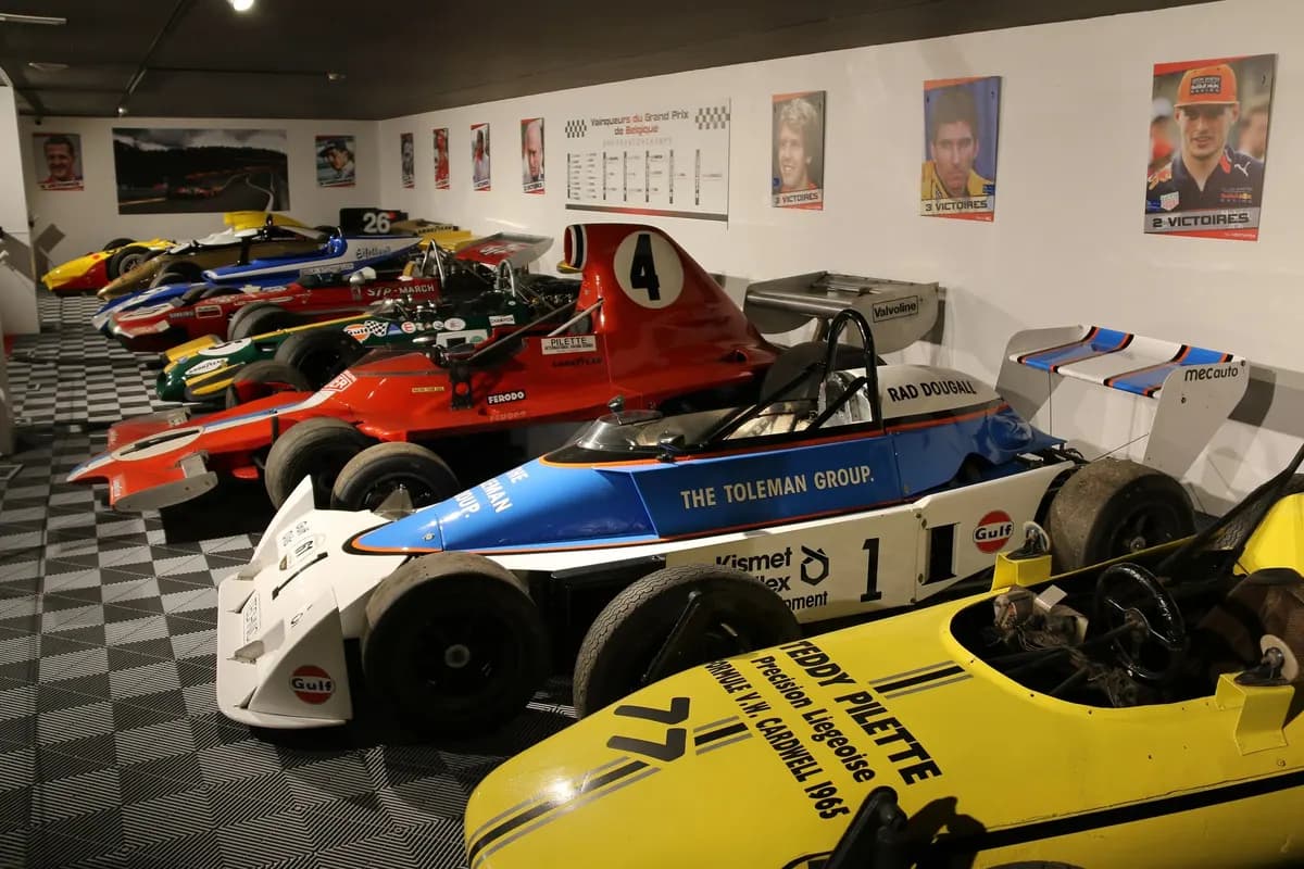 The row of single-seaters in the Spa-Francorchamps Circuit Museum, with a red March in STP colours in the middle distance, a green and yellow Gulf Brabham, a Toleman and portraits of Belgian Grand Prix winners on the wall